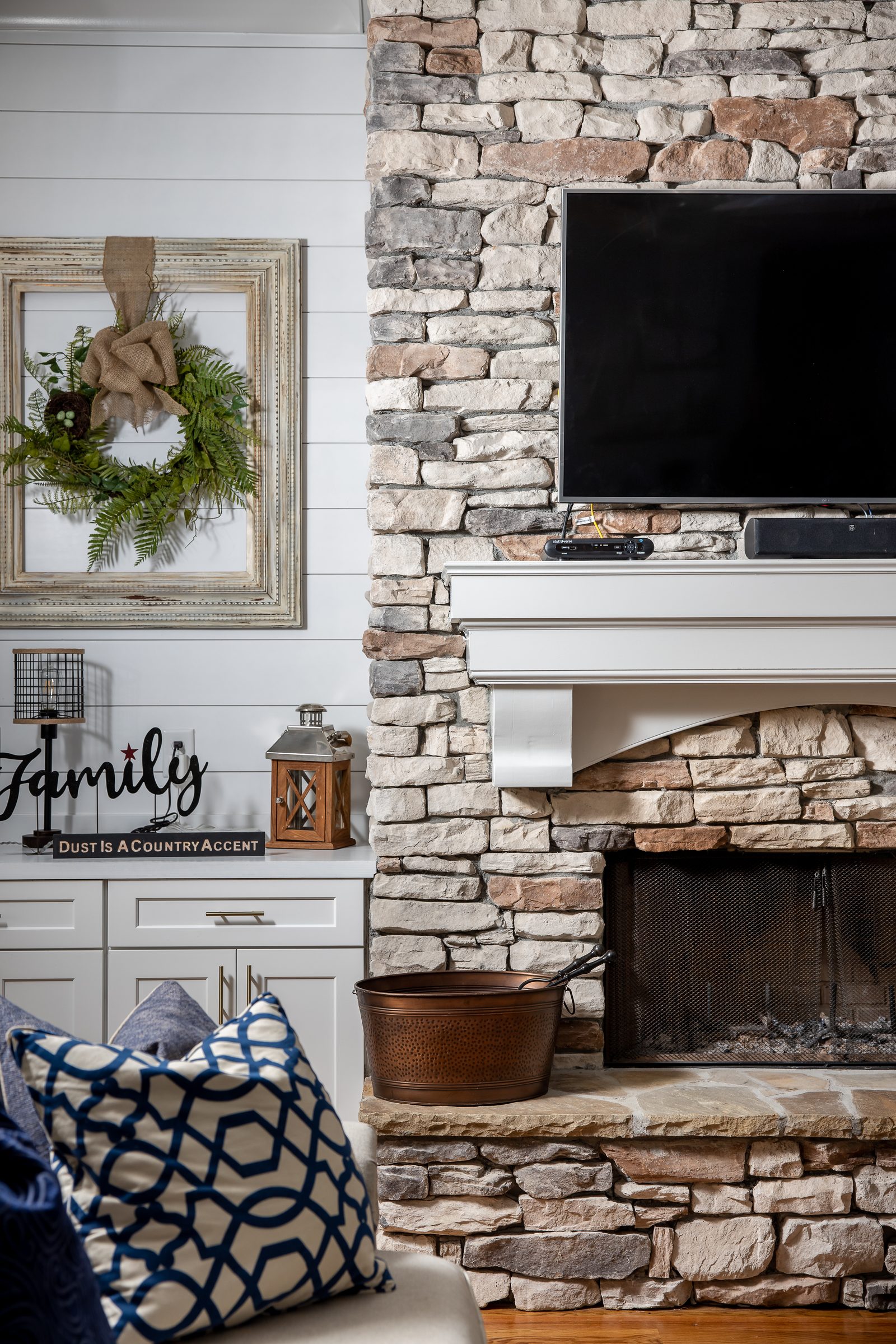 Stacked-stone fireplace with shiplap surround and mounted television — Imbriale, custom home built by Ironwood Construction Group